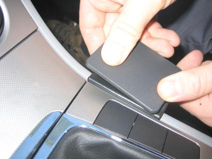 En person trycker på en svart konsoldel för Volkswagen Passat 05-14.