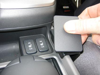 Konsol med värmeknappar och ett avtagbart lock.