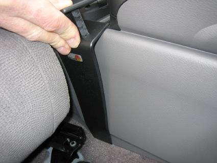 En hand som håller i en del av konsolen i en Honda Civic Hybrid 06-11.