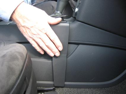 Hand som justerar en del av insidan av en Audi Q7-konsol.