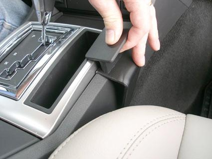 En hand som greppar en del av bilkonsolen i en Chrysler 300C/Touring.