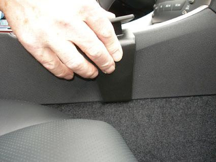 Hand som justerar en del av konsolen i en Lexus IS.
