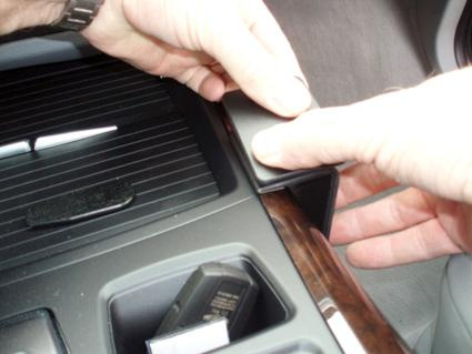 En person installerar en konsolkomponent i en BMW.