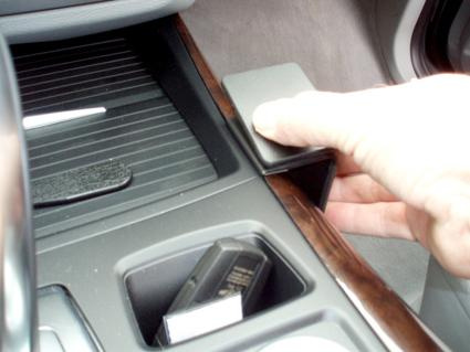 En hand trycker på en konsol i en BMW.