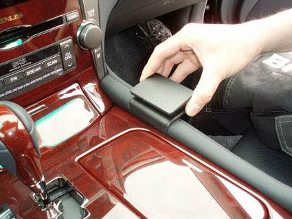 En hand öppnar en konsol i interiören av en Lexus LS.