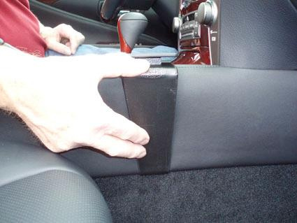 Hand som håller i en svart konsol i en bil.