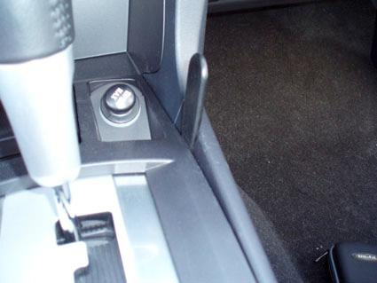 Del av interiör i en Mitsubishi Lancer, med fokus på konsol och växelspak.