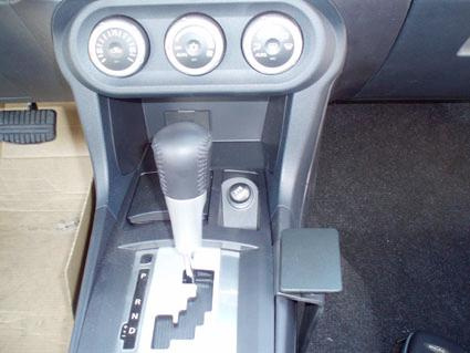 En bilkonsol med växelspak och kontroller för funktioner.