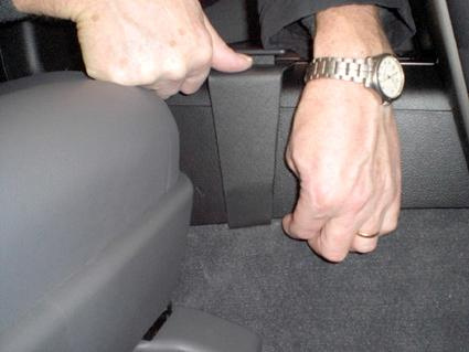 En hand justerar en del av Toyotas konsol inuti en bil.