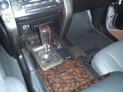 Interiör av Toyota LandCruiser med konsol och växelspak.