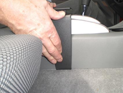 En hand håller i en konsoldel för Toyota Tacoma 05-15.