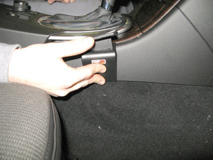 En hand trycker på en knapp vid konsolen i en Opel Insignia.