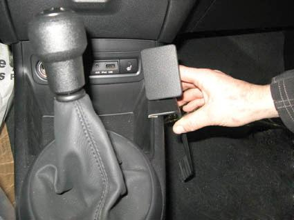 En hand håller i en konsol som installeras vid växelspaken i en Hyundai i20.
