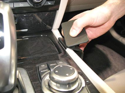 Bild som visar en hand som greppar en del av konsolen i en BMW 730-750.