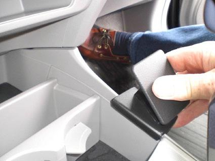 En hand greppar en svart konsoldel i en Honda Insight.