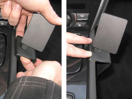 En hand justerar en konsolmonterad enhet i en BMW F07.