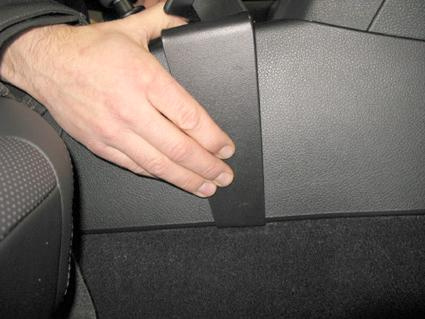 En hand som håller i en konsol till Subaru Outback/Legacy 10-14.