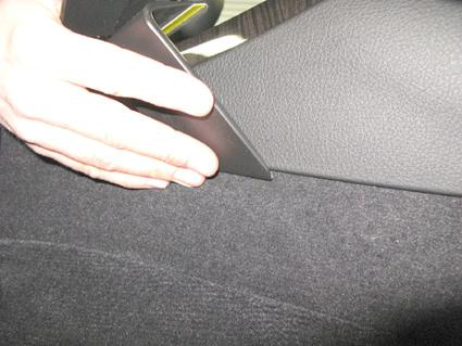 En hand som placerar en del mot bilens inre konsol.