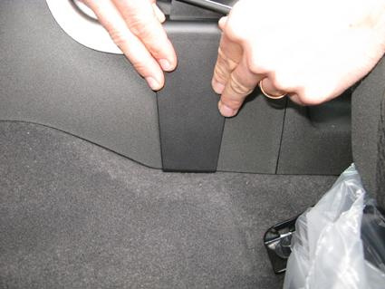 En närbild av en vänsterkonsol i Nissan Navara 11-15 med en hand som justerar den.