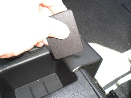 En hand som håller i en svart monteringsbygel för Mazda 2.