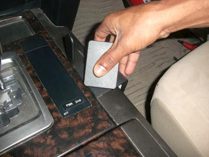 En hand trycker på en knapp i konsolen på en Toyota LandCruiser.