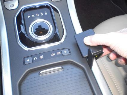 En bilkontrollpanel med växelspak och knappar i en Range Rover Evoque.