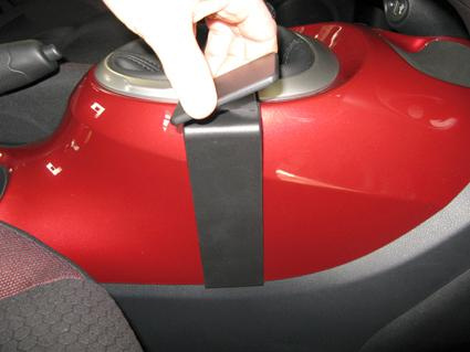 Svart plastdetalj fästs på konsolen i en Nissan Juke.