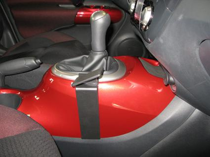 Manuell växelspak och konsol i en Nissan Juke, röd finish.