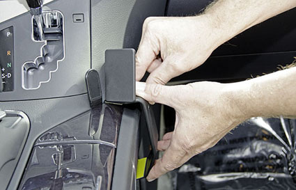 En person installerar en konsol i en Lexus RX 10-15.