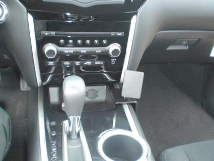 En bilkonsol med ljudsystem, växelspak och förvaringsutrymme.