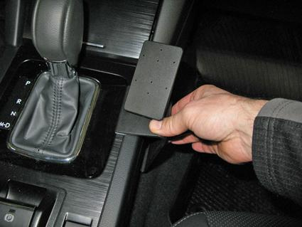 En hand justerar en konsol vid växelspaken i en Subaru Outback.