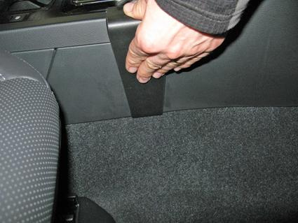 En hand som trycker på en del av en bilkonsol.