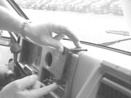 En hand installerar en monteringsbygel i en bil.