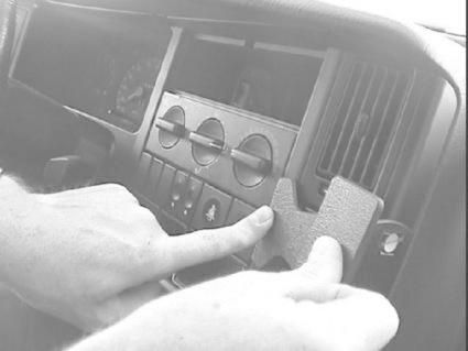 Fingrar monterar en del på en bils instrumentbräda.