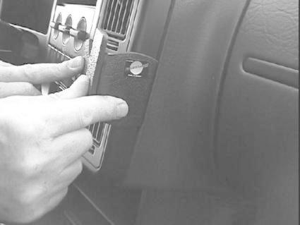 En hand placerar något på bilens inredning.