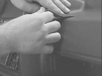 En hand fäster något mot en bilinteriör i en Volkswagen Golf II.