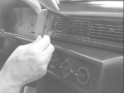 En person monterar en del i bilens instrumentbräda.