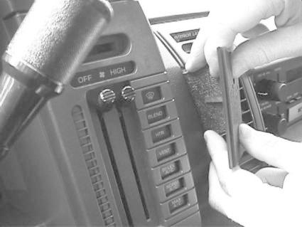 Händer som monterar en bygel på instrumentpanelen i en Chevrolet Astro.