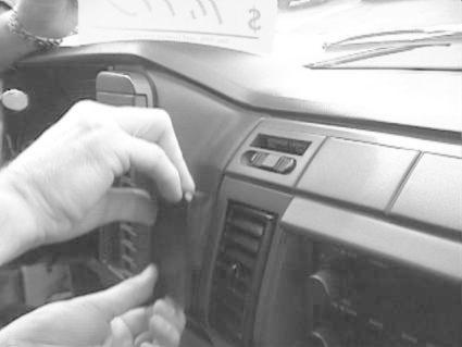 En hand monterar en bygel på instrumentpanelen i en Chevrolet Astro.