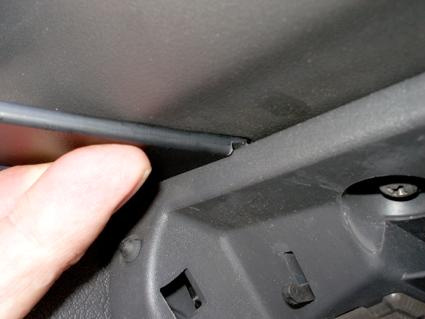 En hand justerar en del av interiören i en Opel Corsa 93-00.