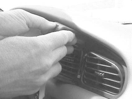 En hand installerar en monteringsbygel i bilens instrumentpanel.