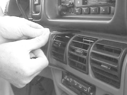 En hand justerar kontrollpanelet i en Chrysler Voyager 94-95.