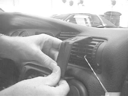 En hand installerar en del i bilens luftventil.