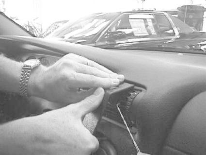 Hand som tar bort ett panelutdrag på en Opel Omega.