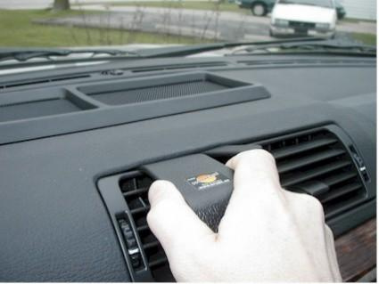 Händer som håller i en monteringsbygel på en bils instrumentbräda.