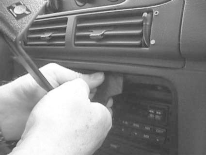 Händer installerar en monteringsbygel i en Ford Taurus.