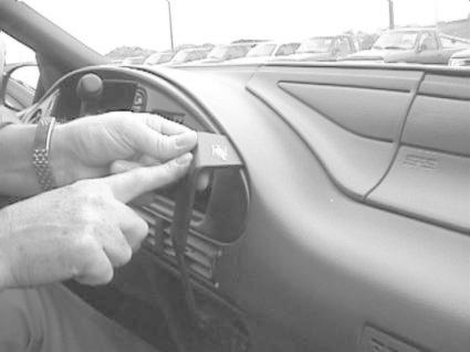 En hand monterar en bygel på instrumentbrädan i en bil.