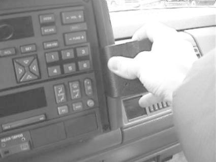 En hand installerar en monteringsbygel i en bils instrumentpanel.