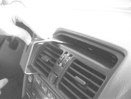 En person använder verktyg för att justera bilens luftventiler.