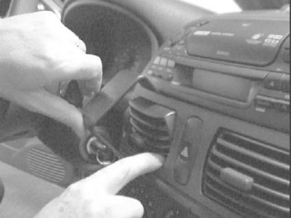 En person justerar reglagen i en bilinteriör.